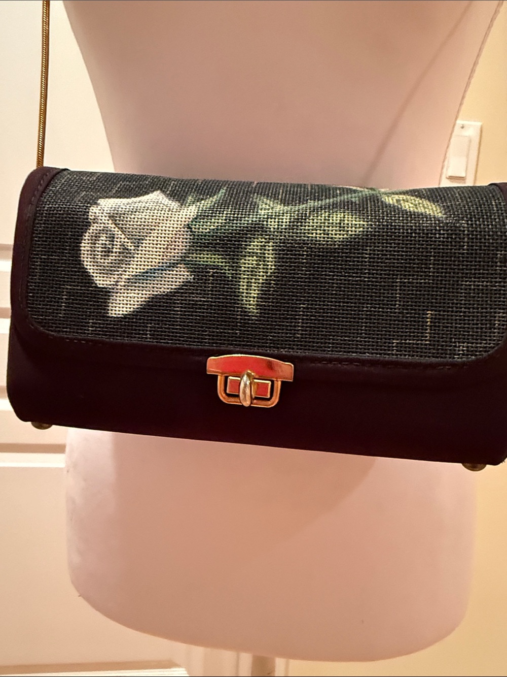 Vintage-Inspired Black Crossbody Bag with White Rose Detail and gold chain.